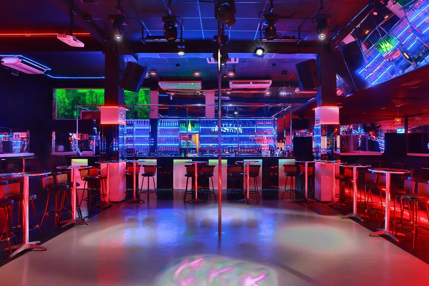 Pista de Dança Casa de swing Asha Club SP iluminada com luzes coloridas e barra de polidance no centro